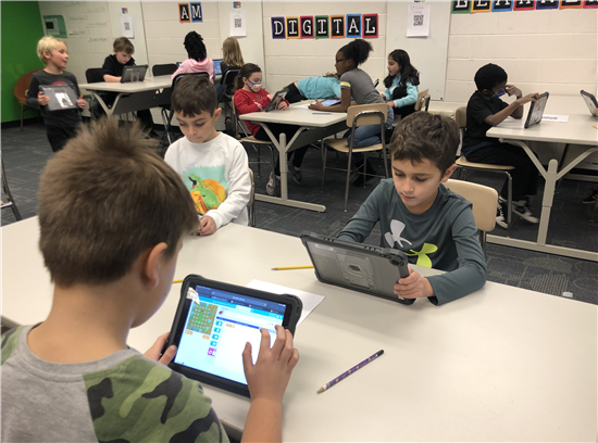 students on iPads coding